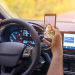 Male driver using smartphone to to take selfie while driving