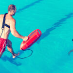 Life guard jumping in a pool