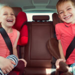 Two kids wearing seat belts