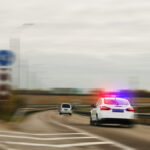 Police car chasing the offender at high speed on the highway .