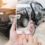 female hold mobile smartphone photographing car accident