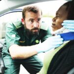 Paramedic placing a cervical collar to an injured woman from car