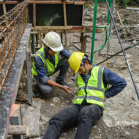 Accident of builder worker in work at construction site. Accident falls from the scaffolding on floor, Foreman support to help the employee body.